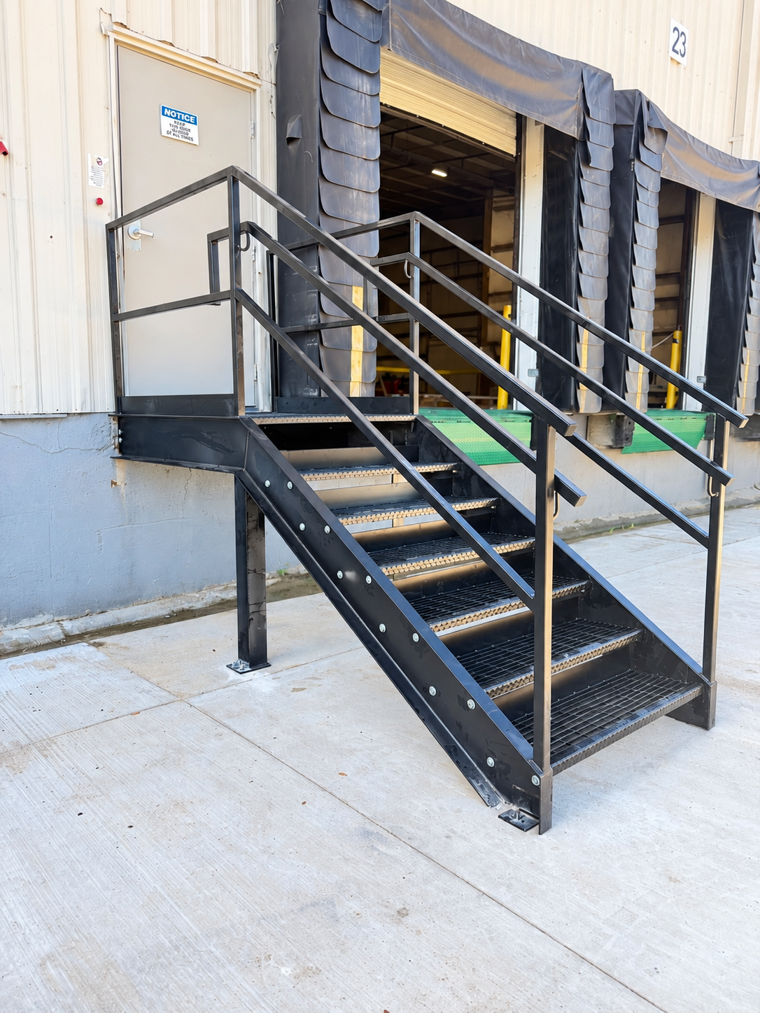 Finished steel staircase with grating treads and handrails at a loading dock