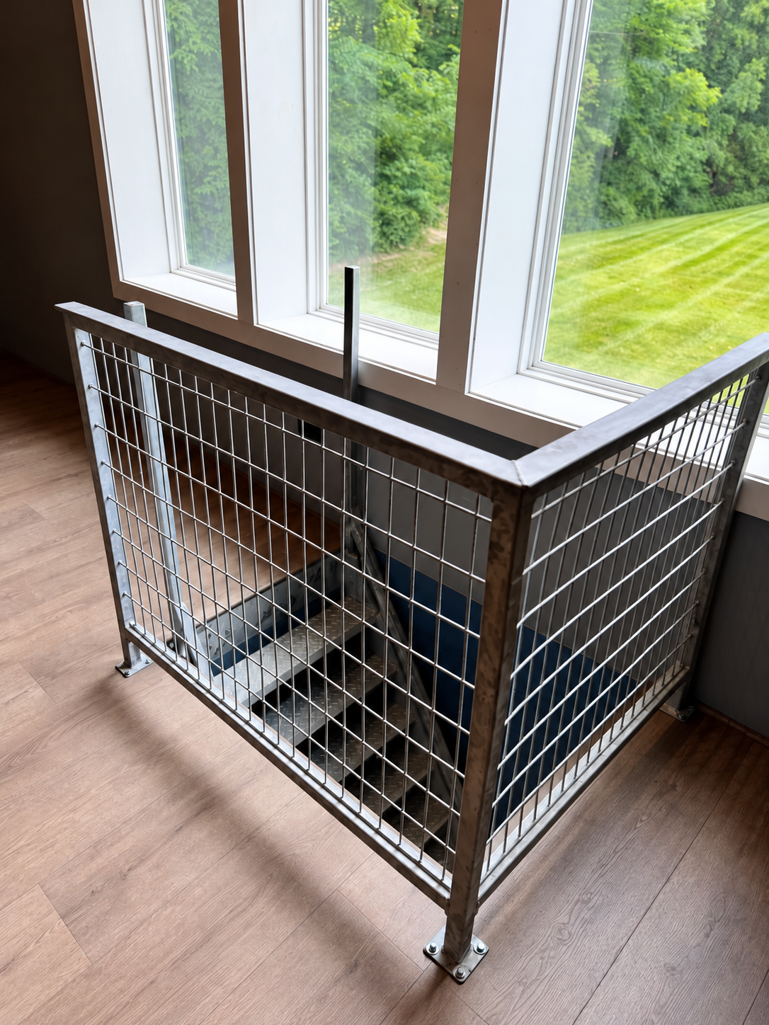 Steel and wire mesh guardrail around an interior stair opening